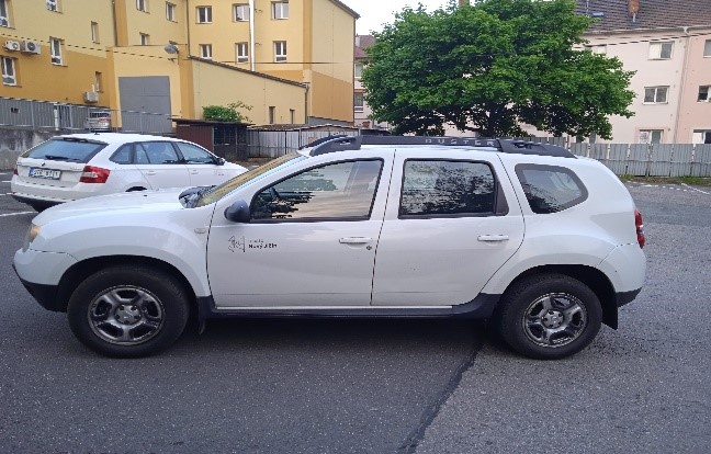 Pohled z boku na vůz Dacia Duster u garáží na Divadelní 8