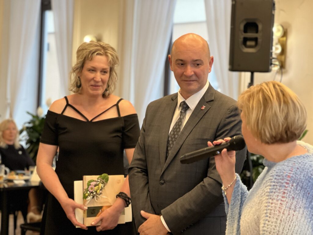 Daniela Susíková mluví do mikrofonu na starostu Stanislava Kopeckého a oceněnou v oblasti sociální Radku Čapkovou 