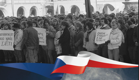 Lidé na černobílém snímku a v popředí česká vlajka