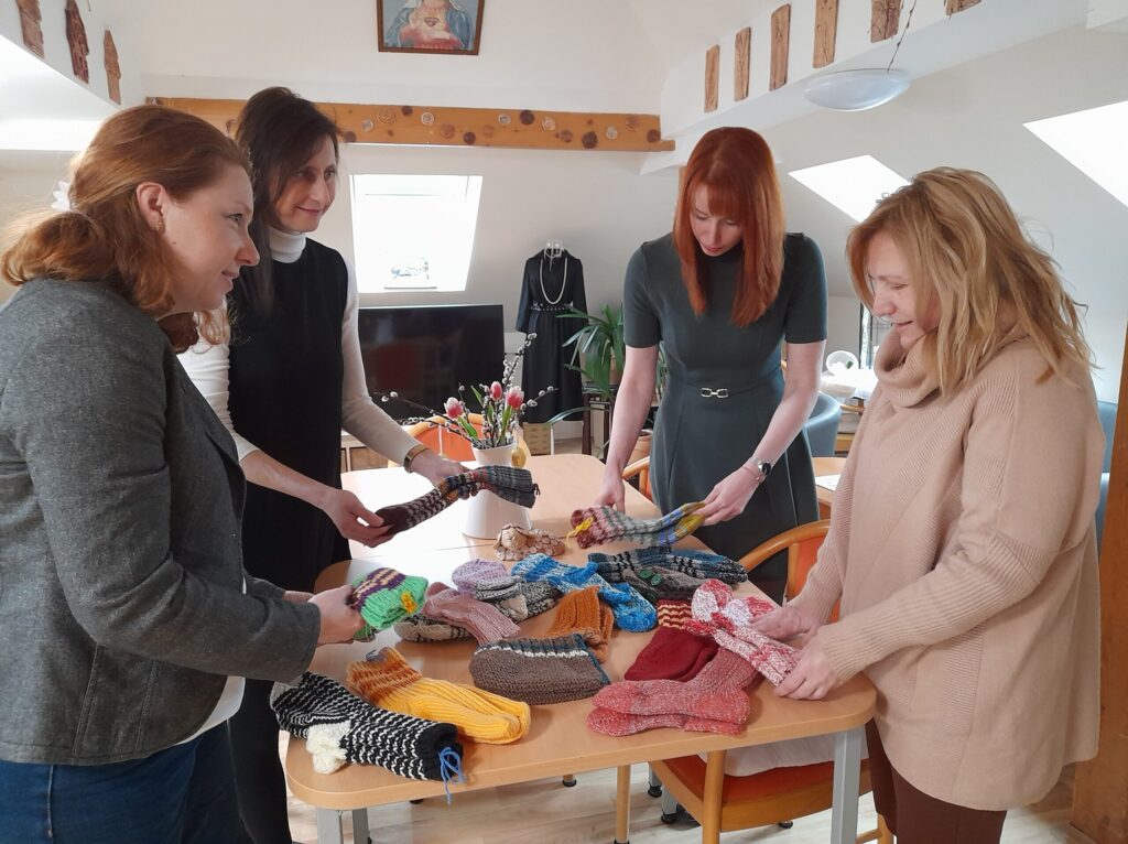 Vedoucí odboru sociálních věcí Daniela Susíková předává ponožky upletené seniorkami ze Straníku pracovnicím Domova Duha