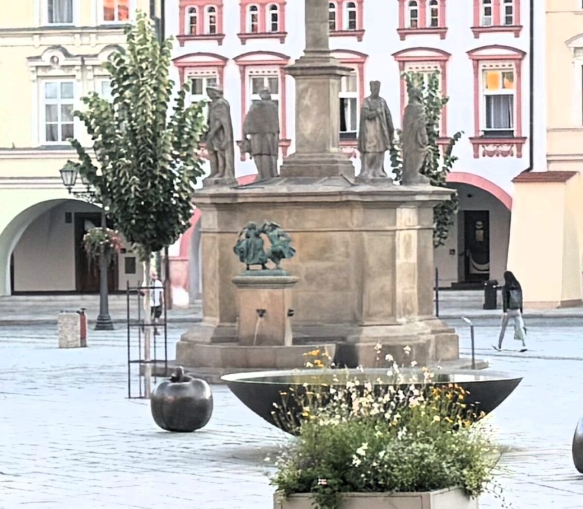 Pohled na sloup se sochou Panny Marie a kašnou